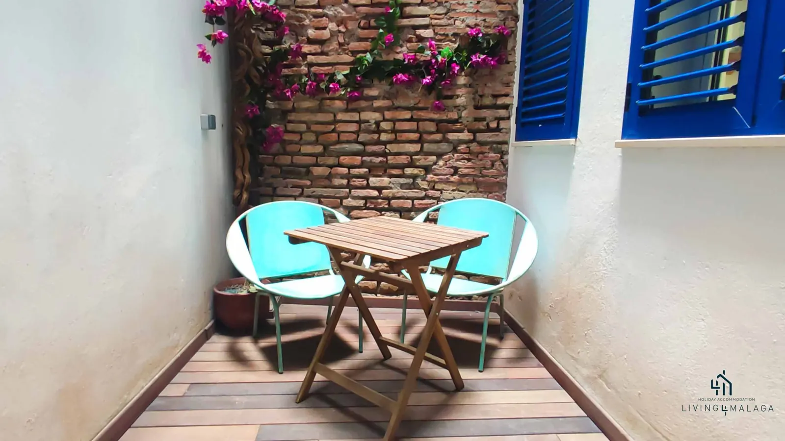 Patio andaluz con buganvillas, mesa y sillas