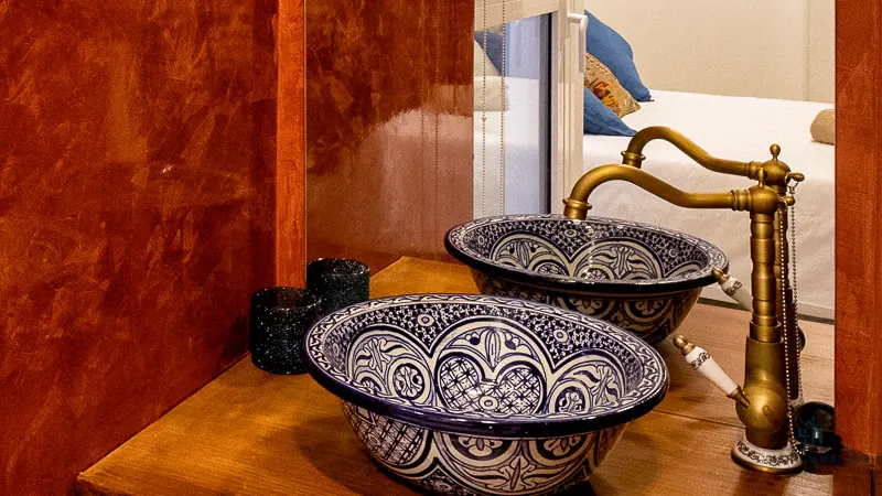 Lavabos de cerámica decorada con grifería dorada